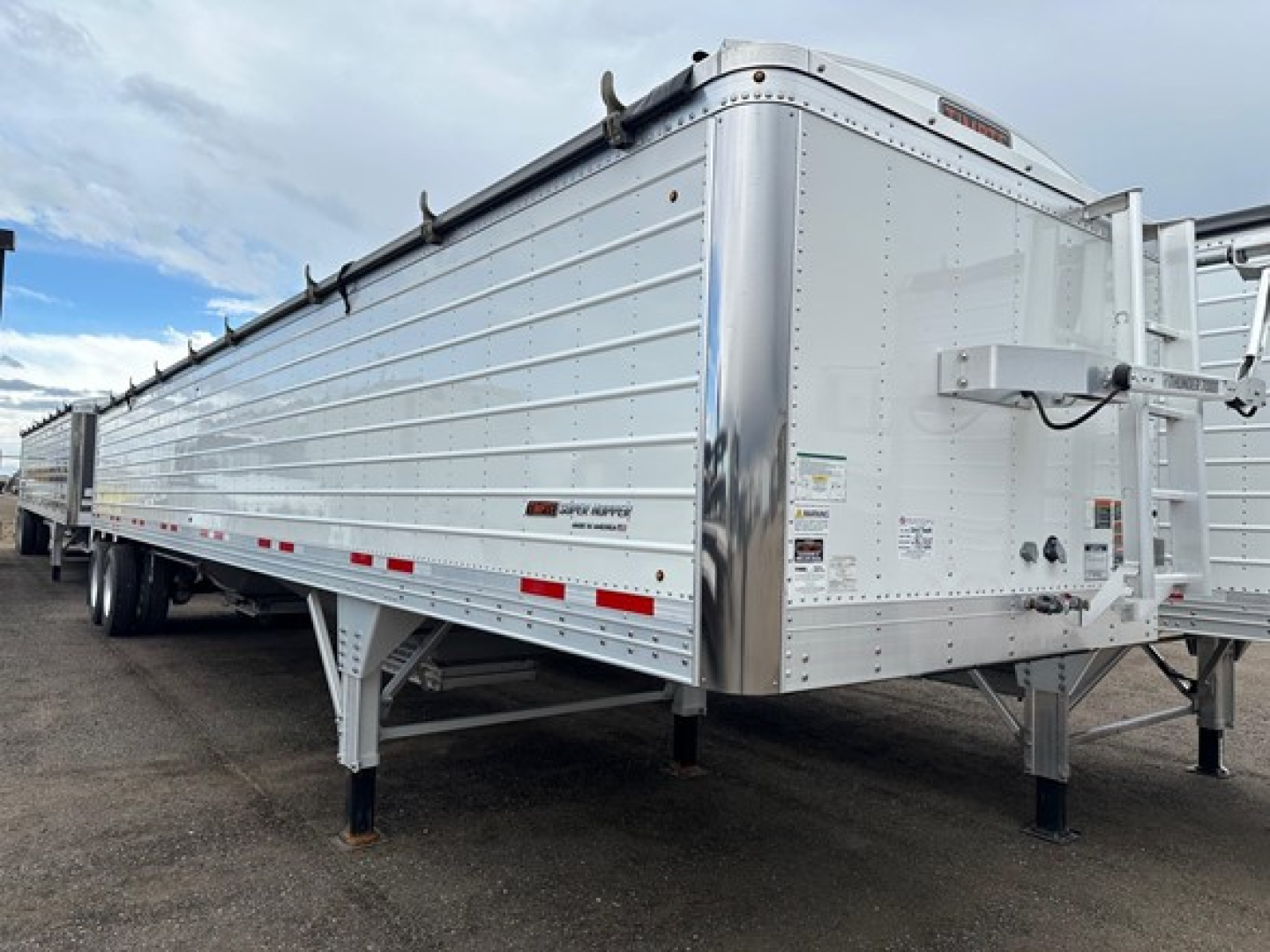Trailer side view showing 66-inch hopper with metal side panels, front skirt, landing gear, and wheel axles; Timpte hopper trailer details visible.