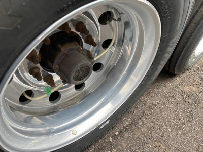 Tire and wheel hub showing steel rim with lug nuts and hub on a 2024 Timpte Super Hopper trailer wheel,”