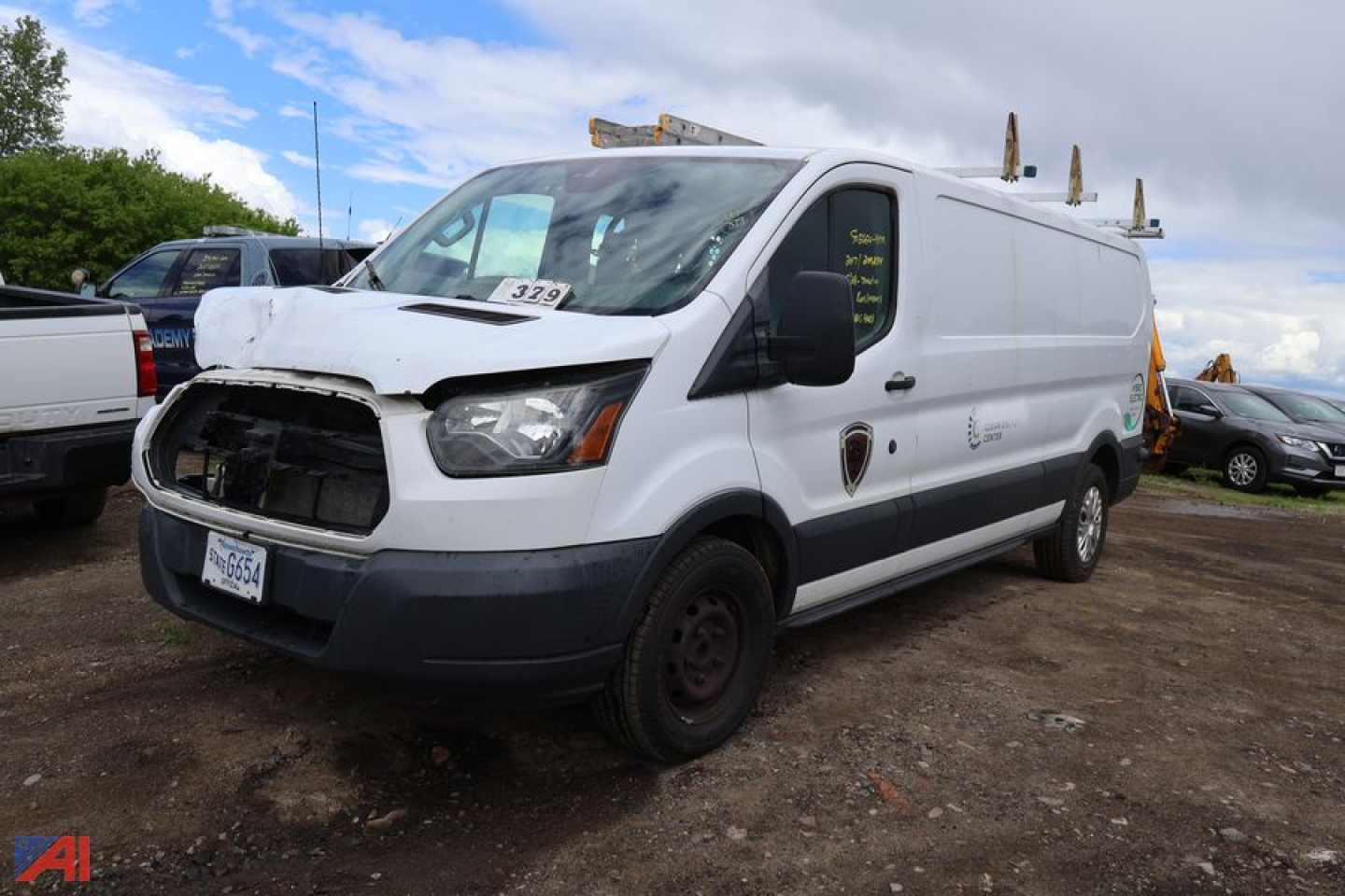 Ford Transit 350 cargo van in service with front damage to grille and hood, white body with black bumper, ladder racks on roof, dark steel wheels, Oregon license plate
