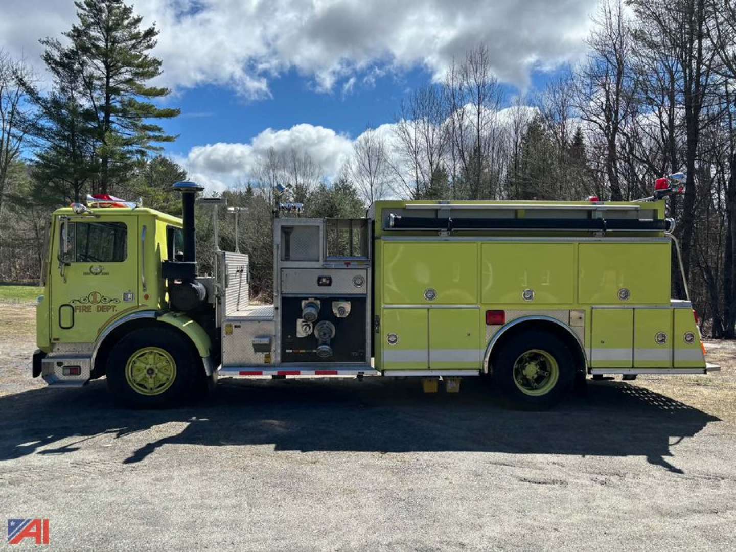1989 Mack fire truck side view showing bright yellow-green body with compartments, water pump panel, and siren lights.