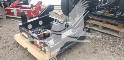 Lowboy trailer equipment with hydraulic controls and hookups, shown on a pallet in an outdoor yard.