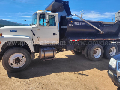 1995 Ford LT9000 dump truck side view showing dump bed, cab with Ford Lariat badge, front wheel, and heavy-duty rear wheels.