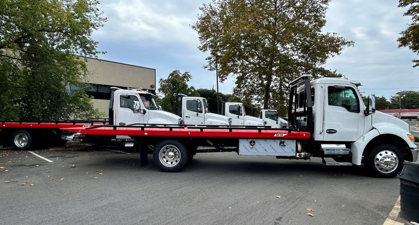 Kenworth T280 tow truck side view with flatbed, white cab, long red tow-bed, VIN 2NK3HM6X6SM135473