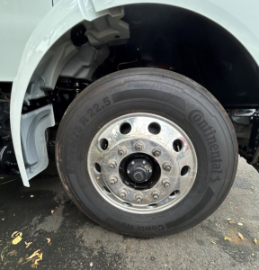 Kenworth T280 front wheel and fender showing Continental tire, wheel hub, and lug nuts.