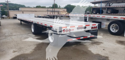 Flatbed trailer showing rear and side, Transcraft logo, D-Eagle II model, chrome wheels, reflective tape, rear lights. 2017 Transcraft D-Eagle II.