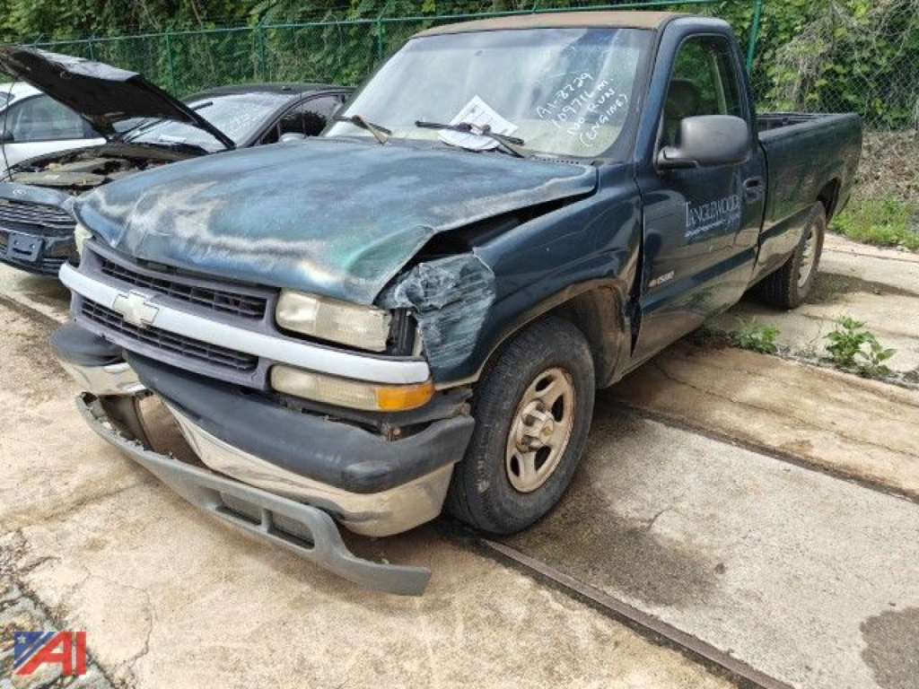 Chevrolet Silverado 1500 pickup truck front-left view with damaged hood, fender, and bumper after collision; blue body; 2-door regular cab; damaged front bumper and wheel area.