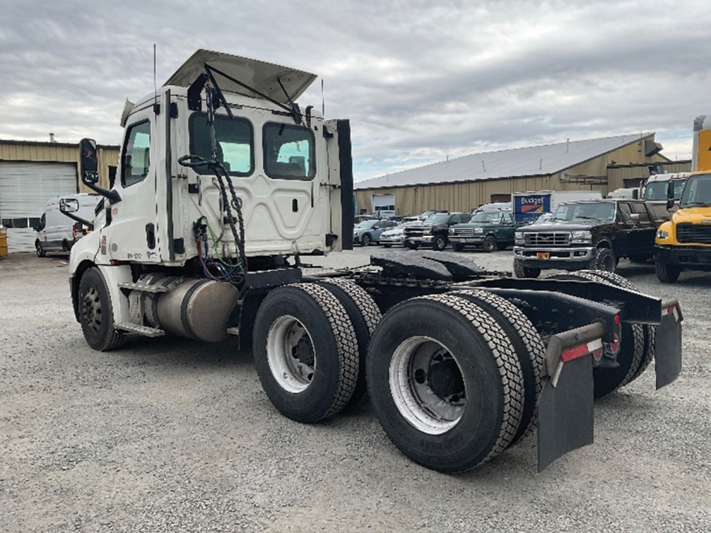 Freightliner Cascadia126 truck chassis showing rear triple-axle setup and cab in white.