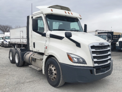 Freightliner Cascadia126 conventional daycab truck showing front and left side with white cab and sleeper, black bumper, and dual rear axles.