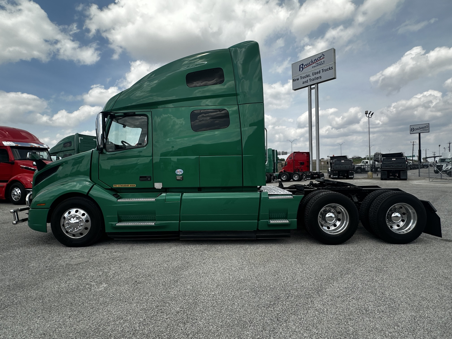 Volvo VNL64T760 cab in green side view showing sleeper cab and rear dual axles.