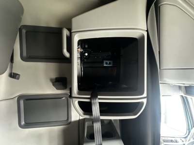 Truck interior center console with empty cup holder area and open storage compartments; no easily readable labels.