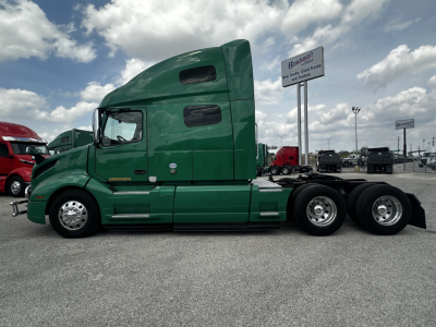 Volvo VNL64T760 cab in green side view showing sleeper cab and rear dual axles.