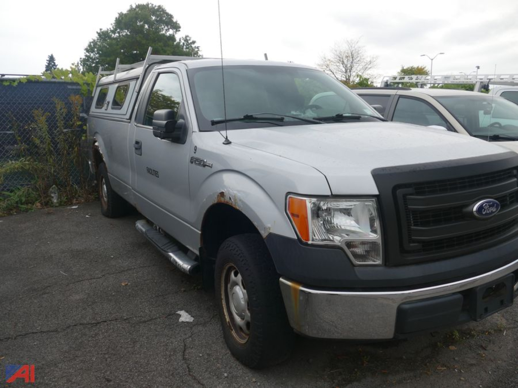 Ford F-150 pickup truck in 2WD configuration showing front grille, headlights, and side profile with camper shell and running boards.