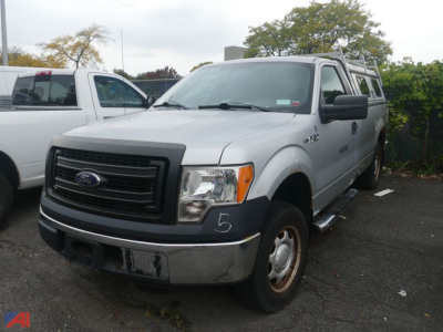 2013 Ford F-150 pickup truck in a parking lot, white exterior, front grille with Ford emblem, black bumper, side steps, extended cab.