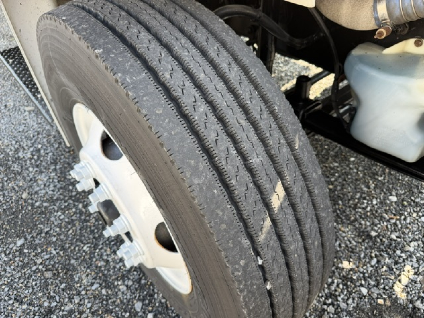 Truck wheel and dual-tire front axle showing tread and rim, part of a Freightliner M2-106 vocational truck.