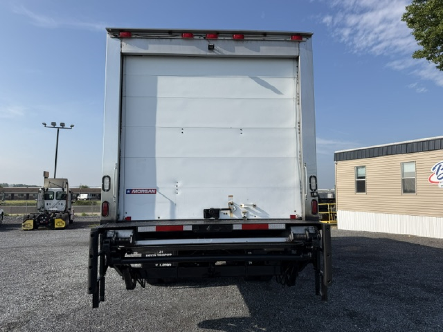 Rear view of a 2016 Freightliner M2-106 refrigerated truck showing closed trailer doors and rear hitch assembly.