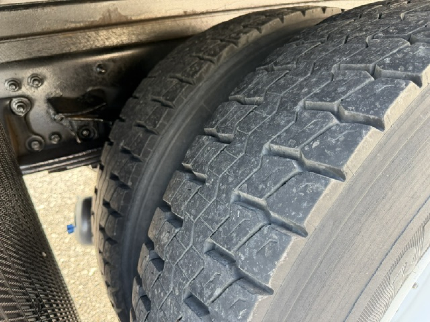 Freightliner M2-106 wheel/tire view showing heavy tread and undercarriage.