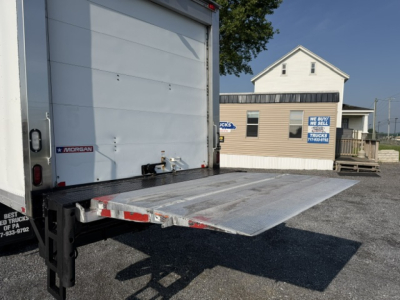 Truncated steel drop-down liftgate on Freightliner M2-106 truck with rear cargo area open, aluminum platform extended.