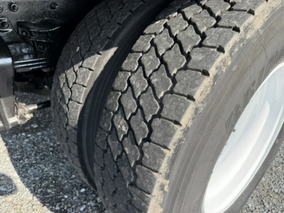 Truck wheel and tire close-up on a Freightliner M2-106 chassis showing heavy-duty tread and rim.
