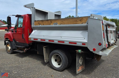 Dump truck showing red cab and silver dump bed with plow equipment in rear, side view of International TerraStar truck