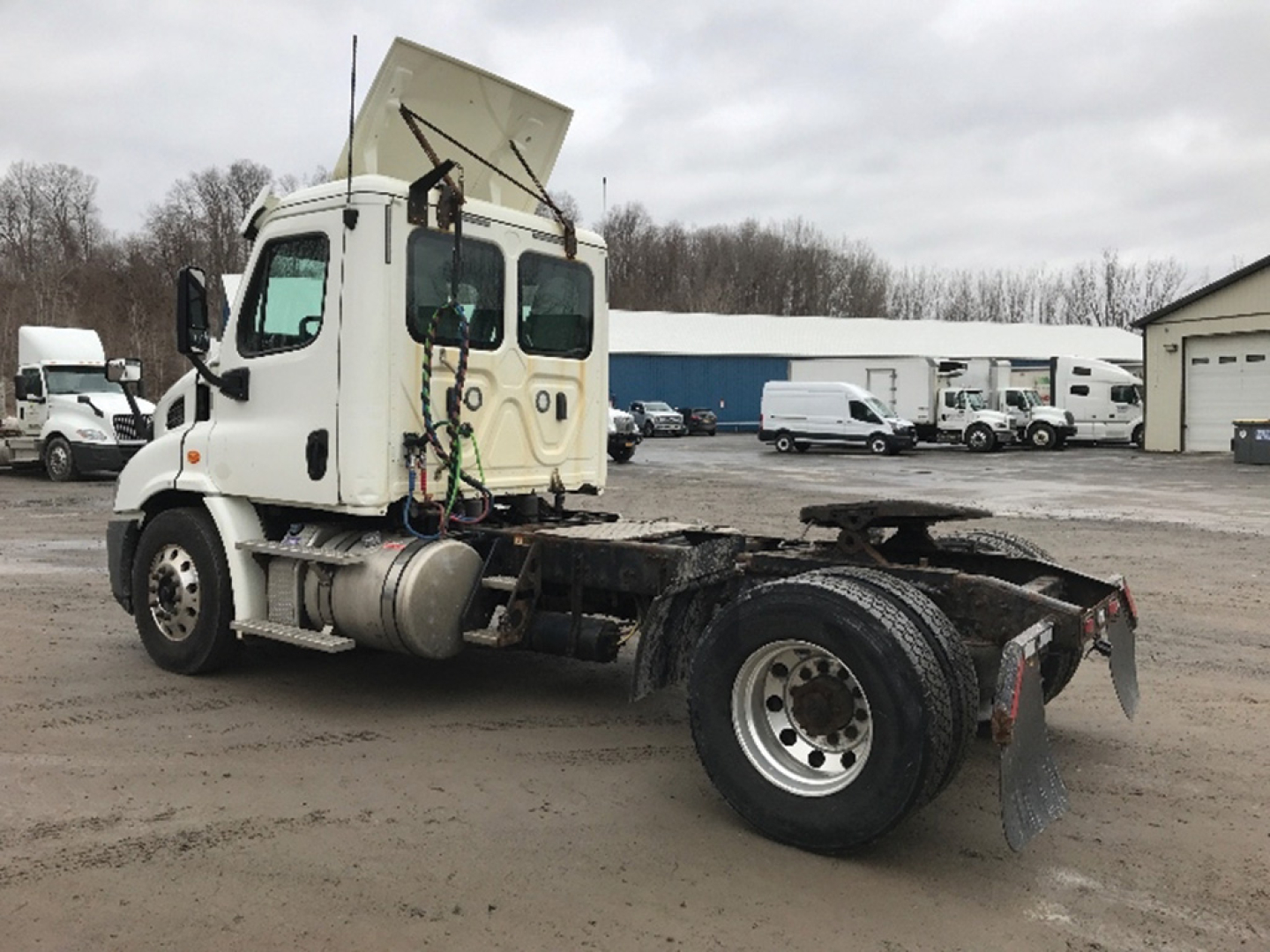 Truck cab and chassis of a 2018 Freightliner Cascadia 113 conventional daycab, side view, with exposed engine bay and rear dual-wheel axle; stock number 550401.