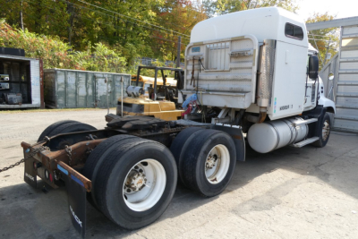 Truck view of a 2006 Mack CXN613 conventional sleeper tractor chassis rear wheels and cab, visible sleeper cab, dual rear axles, fuel tanks, and rear hitch.