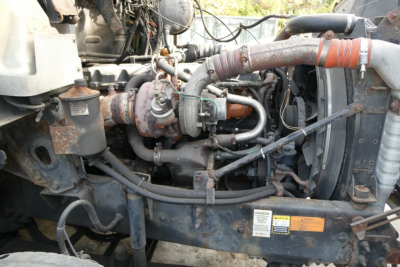 Engine bay of a 2006 Mack CXN613 truck showing intake hoses, turbocharger, and radiator components.