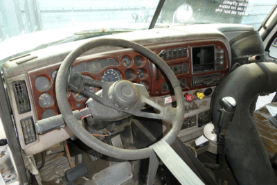 Mack CXN613 truck cab interior showing steering wheel dashboard gauges and controls