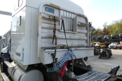 Mack CXN613 sleeper tractor rear view showing chrome toolbox and coiled air line.