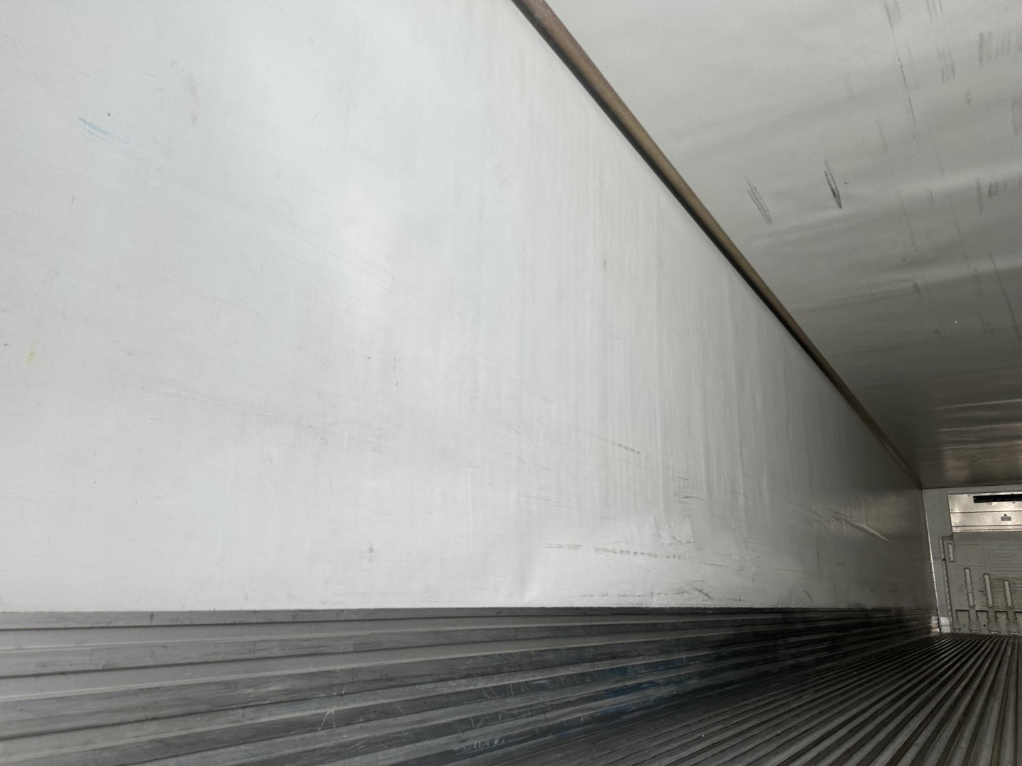 Utility 3000R trailer interior cargo area showing aluminum wall and ribbed floor.