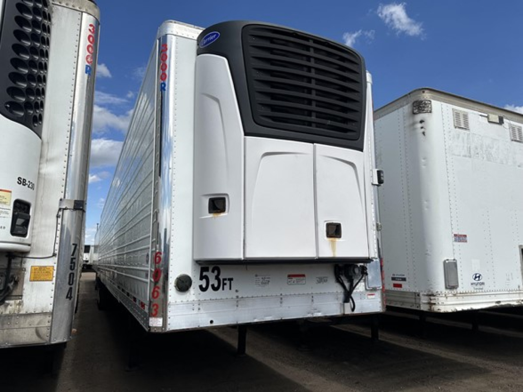 Utility 3000R trailer refrigeration unit mounted on front with white body and black vent, 53 ft decal on curb side, other trailers visible.