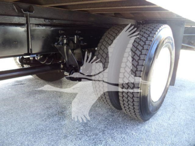 Truck rear axle and dual wheels under cargo box of a 2019 International Durastar, showing suspension and leaf springs.
