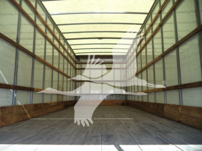 Truck trailer interior showing empty cargo area with wooden floor and metal side walls.
