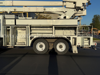 Truck side view showing a bucket boom on a 2010 International 7500 with multiple compartments and stabilizers.