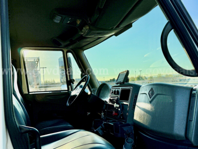 Truck cabin interior of an International 7500 showing dashboard, steering wheel, and driver’s seat.
