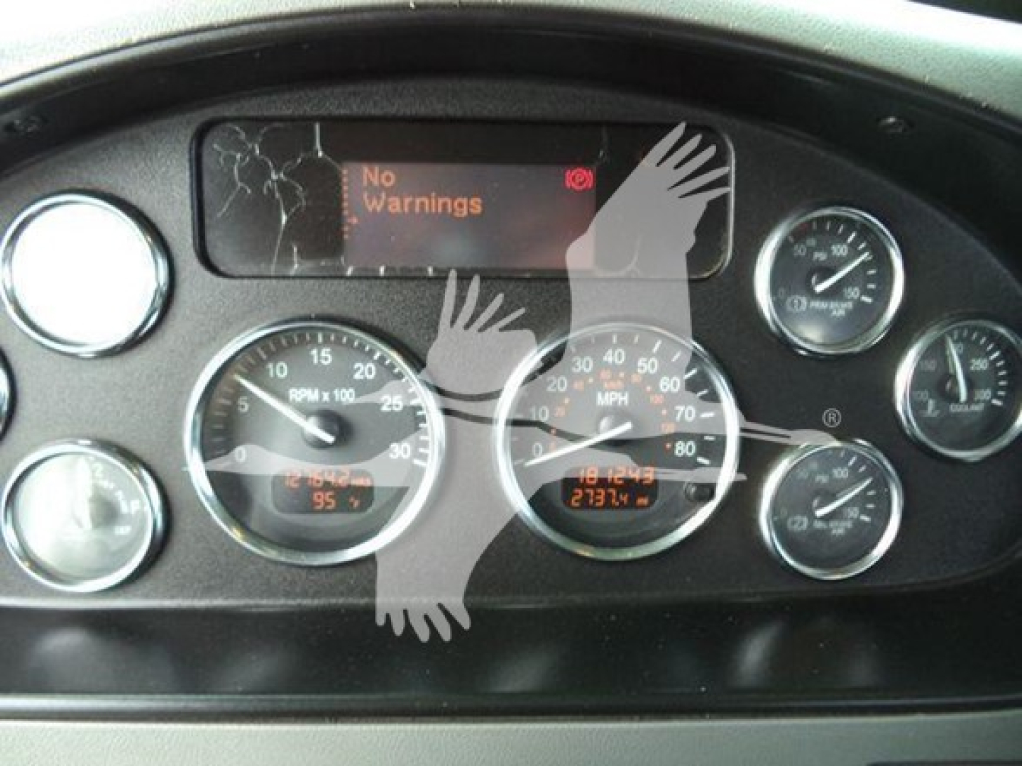 Peterbilt dashboard cluster showing multiple gauges and a digital display with 'No Warnings' text.
