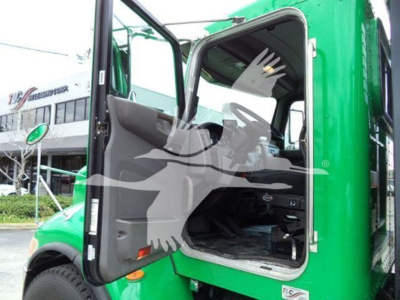 Peterbilt 348 roll-back truck with driver door open, green cab, interior visible.