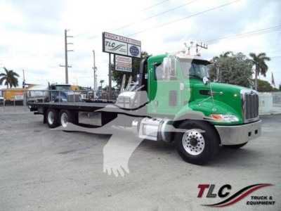 Peterbilt 348 rollback truck in green and silver profile view showing cab and flatbed with dual rear axles.