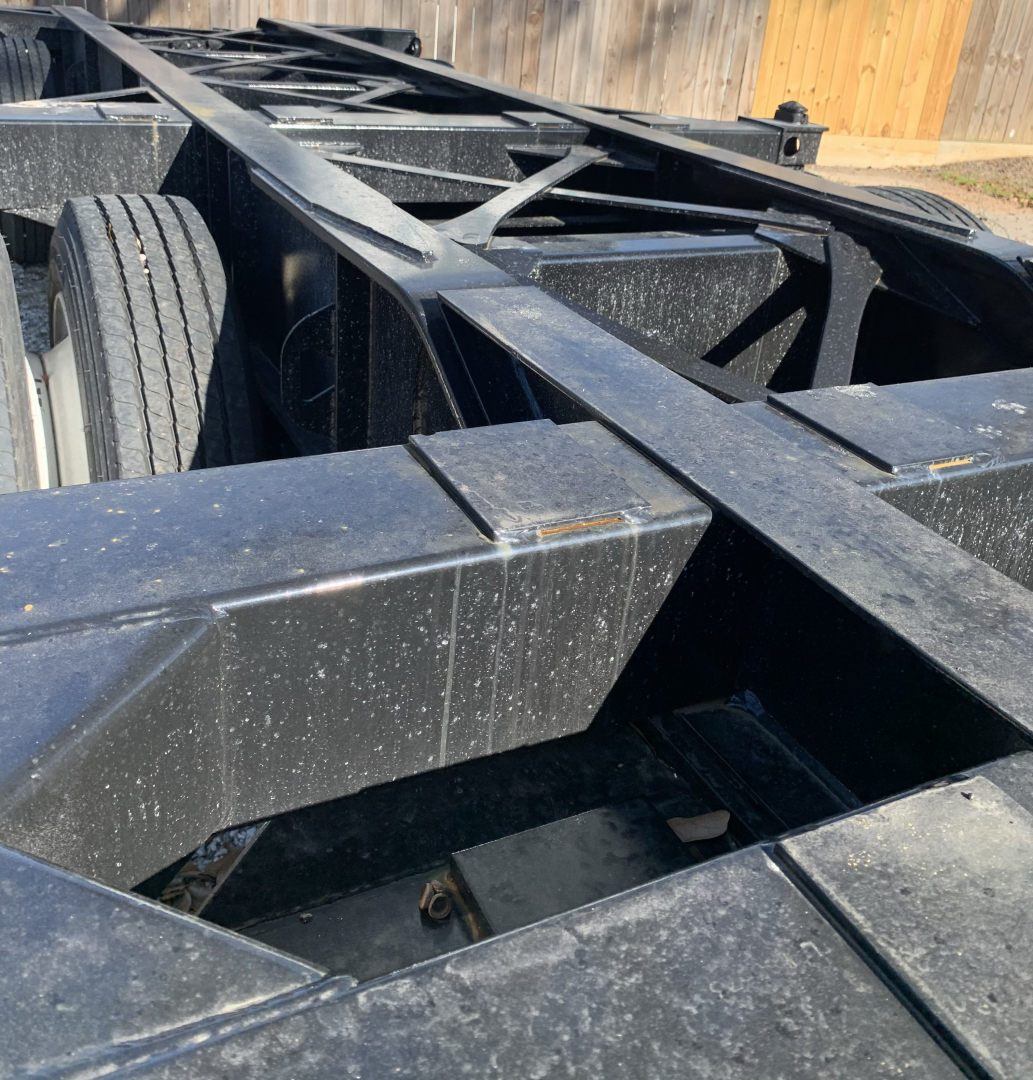 Chassis frame of a 2020 Pro-Haul 43' Sand trailer showing black steel lattice frame and dual rear wheels, with visible crossmembers and deck area.