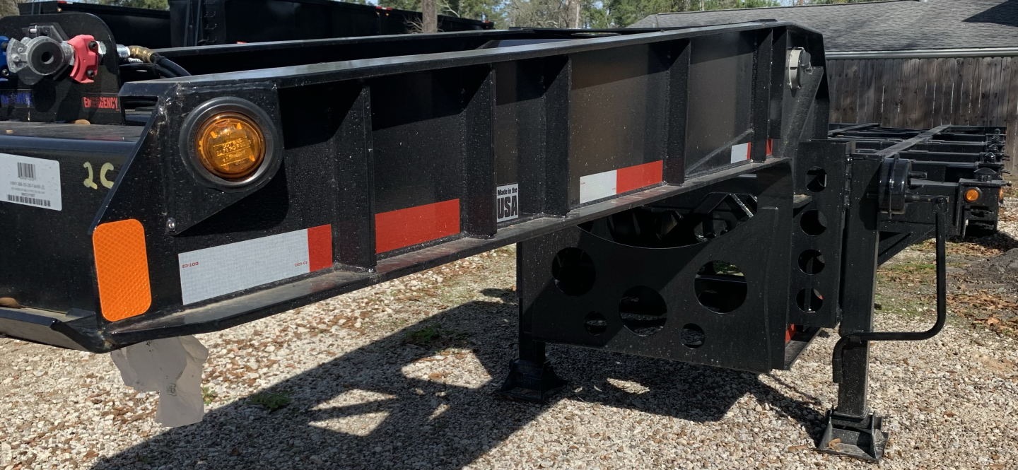 Trailer chassis side view showing heavy-duty black frame with reflective red/white stripes and support legs.