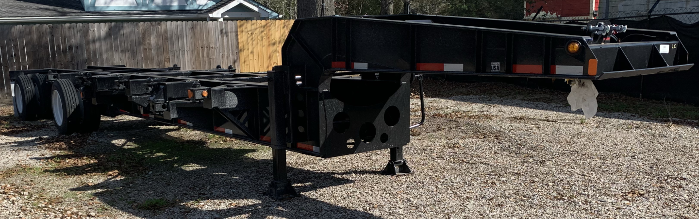 Trailer chassis showing gooseneck area and extended frame with landing gear and dual wheels in a yard.