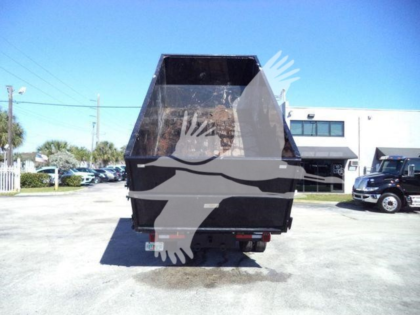 Rear view of a Chevrolet Silverado 6500HD dump truck with a black dump bed in-service