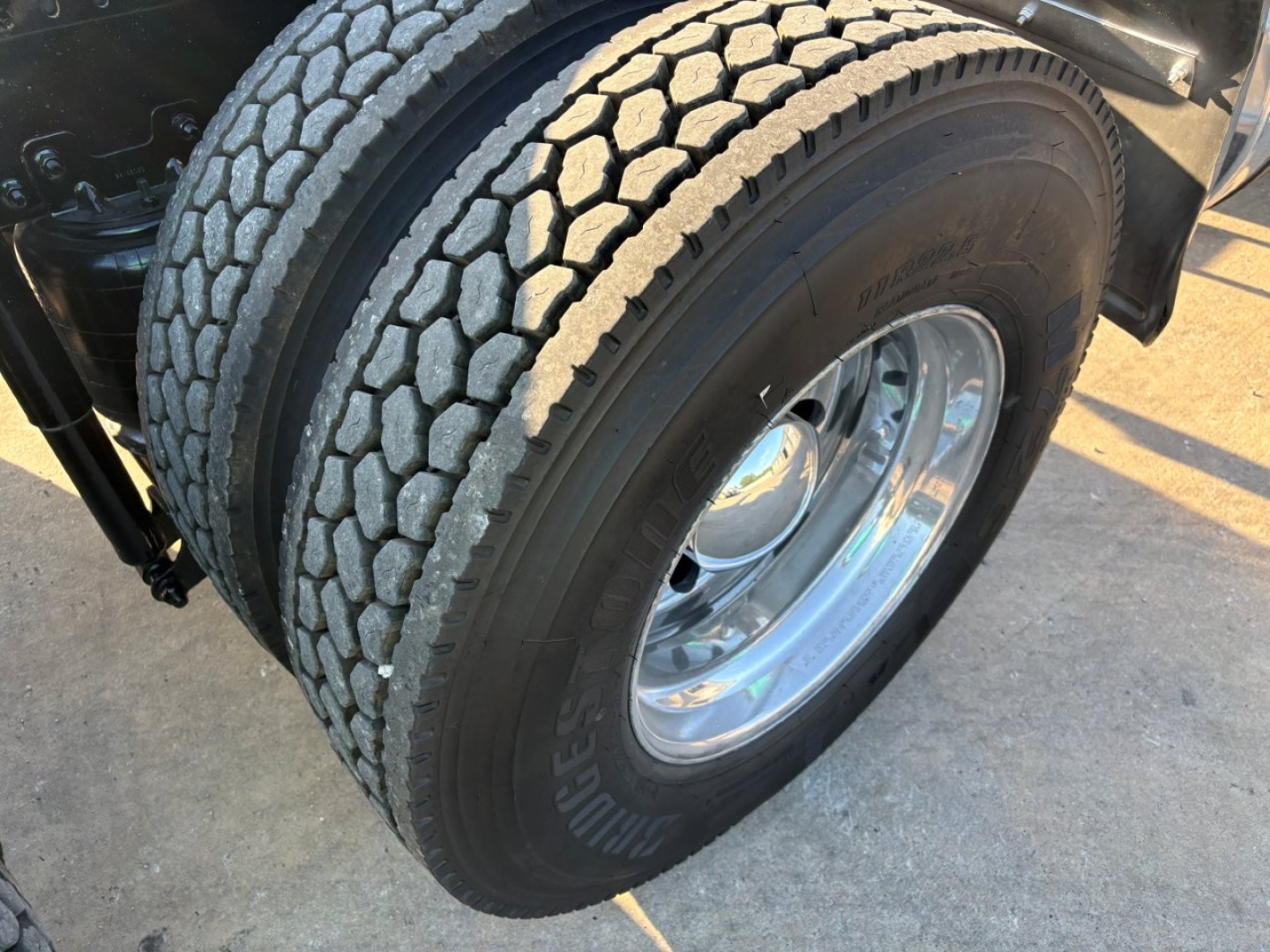 Front dual rear tires of a 2020 Mack PI64T conventional daycab with tread detail and polished chrome rims.
