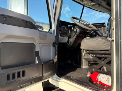 Cab interior of a 2020 Mack PI64T truck showing steering wheel, dashboard, and driver seat with a red fire extinguisher at the floor.
