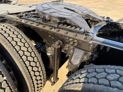 Mack PI64T tractor-trailer chassis with 2 rear dual tires, fifth wheel, and suspension components visible.