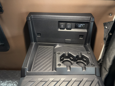 Truck interior center console showing cup holders and power/auxiliary ports panel.