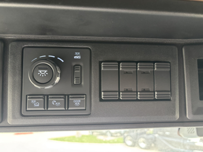 Truck dash panel showing headlight control knob and several blank switch panels.