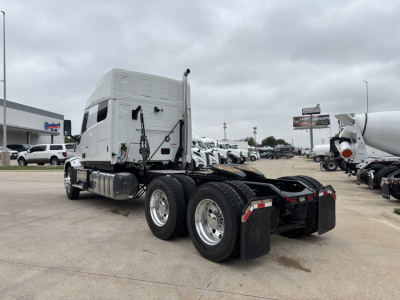 Truck tractor rear view showing chassis and dual rear axles, fuel tanks, exhaust stack, and fifth-wheel area.