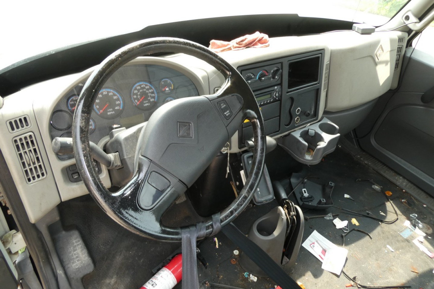 Cab and chassis interior of a 2012 International Terrastar showing steering wheel, dashboard gauges, and center console with scattered papers.