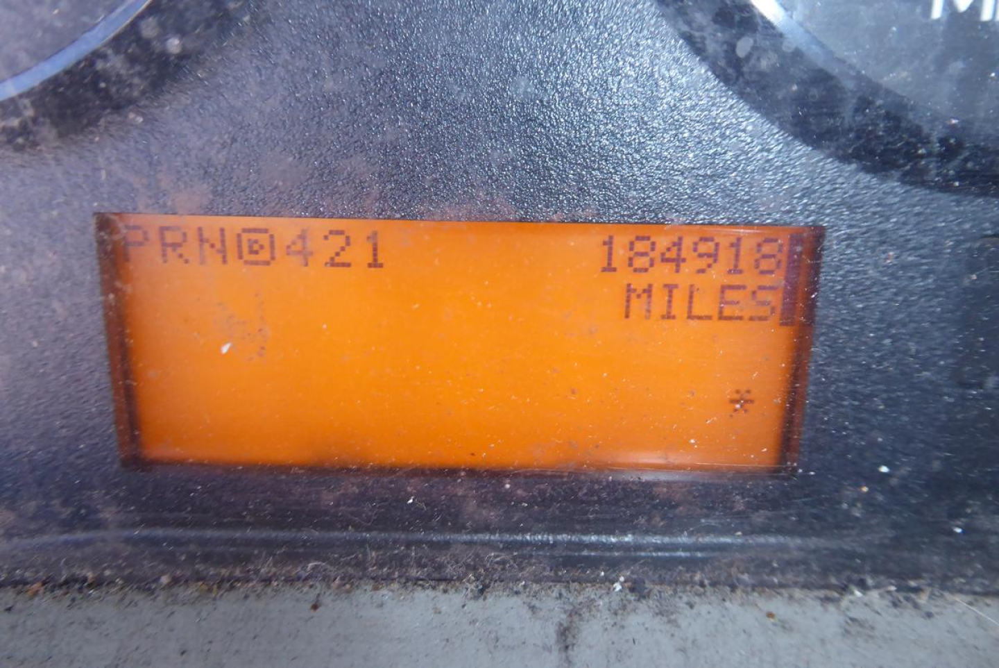 Dashboard LCD display showing PRN0421 and 184918 MILES with faded digits in orange backlight.