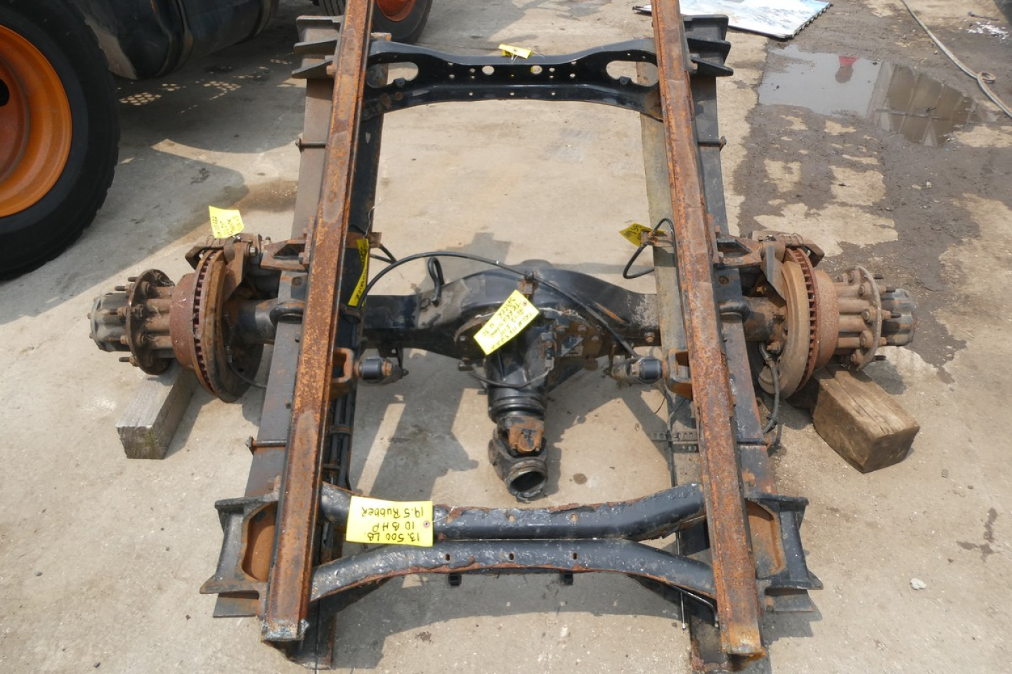 Frame rails and rear axle assembly showing rusted components and suspension mounts.
